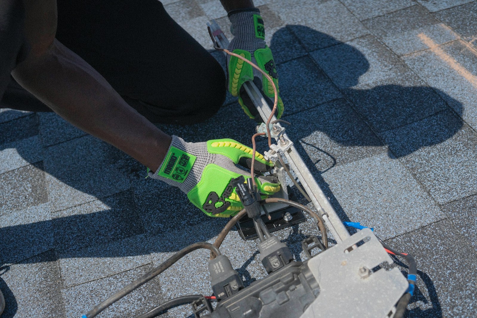 Worker installs wires on a roof.