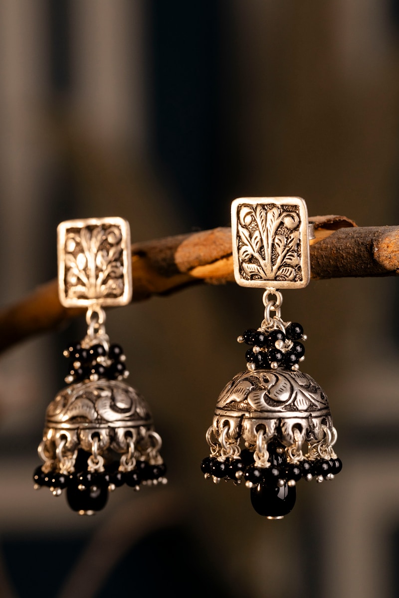 A pair of silver bells hanging from a tree branch